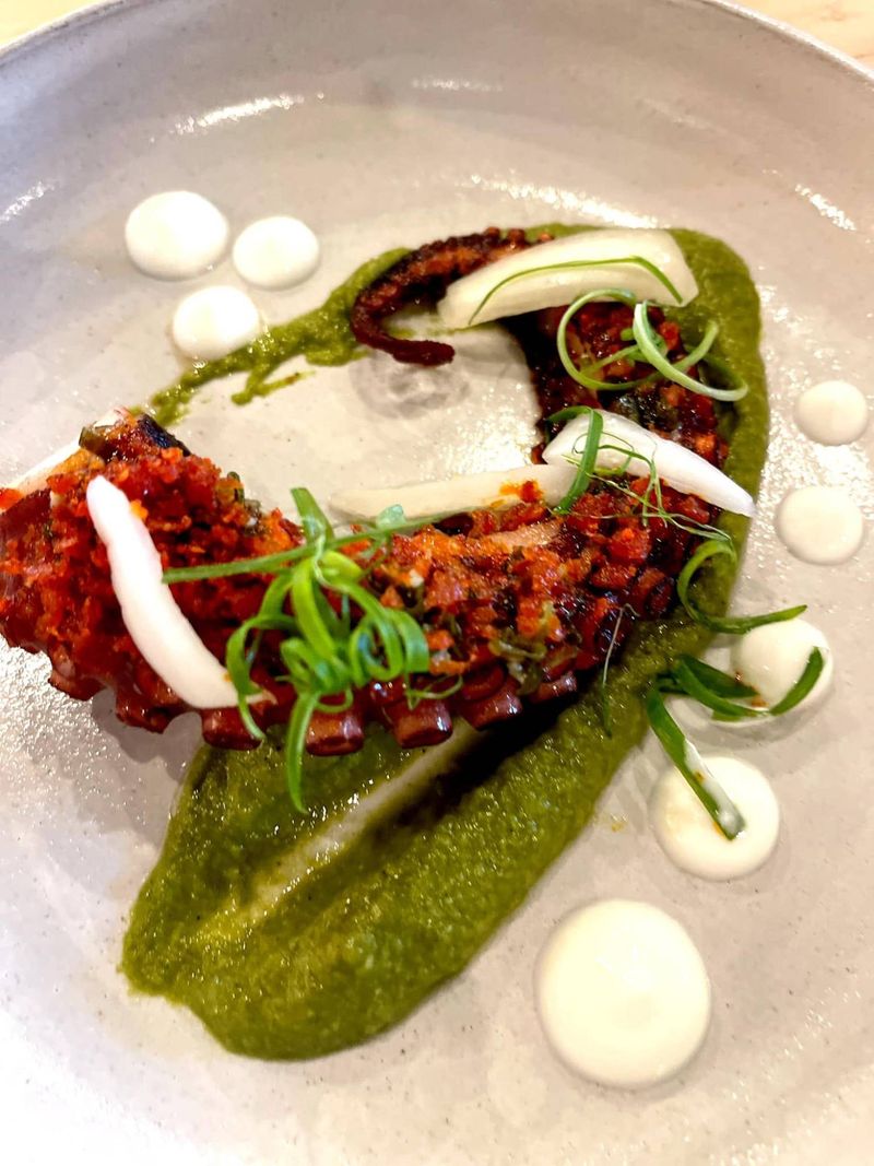 Grilled octopus on a bright green herb purée